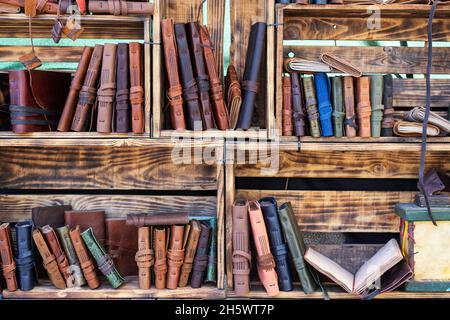 vue horizontale des carnets faits à la main avec une couverture en cuir sur les étagères en bois. maroquinerie utilisant des matériaux recyclés Banque D'Images