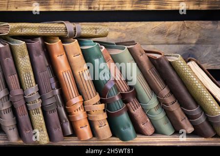 vue horizontale des carnets faits à la main avec une couverture en cuir sur les étagères en bois. maroquinerie utilisant des matériaux recyclés Banque D'Images