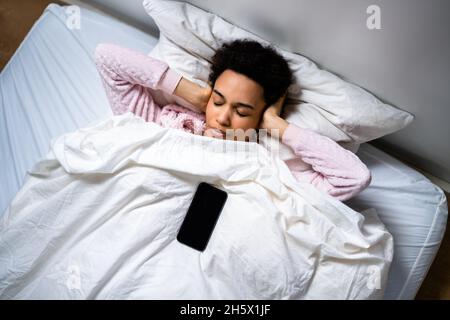 Réveil afro-américain avec alarme téléphonique en stress Banque D'Images