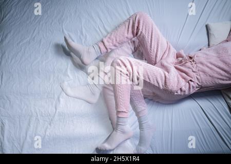 Femme afro-américaine avec RLS - syndrome des jambes sans repos.Dormir dans le lit Banque D'Images