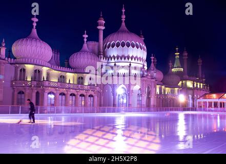 Le Pavillon Royal, Brighton, est éclairé par des illuminateurs LED de couleur derrière la patinoire d'hiver érigée dans les jardins du Pavillon.Brighton, East Sussex, Angleterre, Royaume-Uni. Réparer la surface de la patinoire ce pour une autre séance de patinage. Banque D'Images