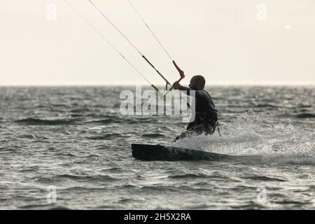 Ortigueira, Espagne - 18 août 2020 : Kitesurfer pratiquant le sport, le kitesurf ou le kitesurf, dans le Rias Altas, en Galice, au milieu d'un beauffu Banque D'Images