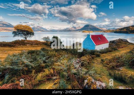 Le superbe cottage au toit rouge qui se trouve non loin de la rive du Loch Shielddaig sur la route d'APPLECROSS.avec une vue fantastique sur le loch Banque D'Images