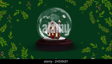 Image de boule à neige avec maison à noël sur les feuilles Banque D'Images