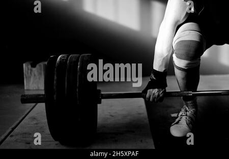 Homme pratiquant l'haltérophilie dans une salle de sport Crossfit Banque D'Images