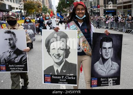 New York, États-Unis.11 novembre 2021.Un jeune qui porte des photographies des membres du service de la Seconde Guerre mondiale participe à la 102e Veterans Day Parade le long de la 5e Avenue à New York, New York, le 11 novembre 2021.(Photo de Gabriele Holtermann/Sipa USA) crédit: SIPA USA/Alay Live News Banque D'Images