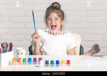 Émotions amusantes pour les enfants.Les petites filles dessinant des images colorées avec des crayons de couleur dans la salle de classe de l'école.Peindre les enfants.Les enfants font de l'art et de l'artisanat Banque D'Images