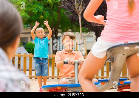 Compagnie d'enfants teetering sur l'oscillation Banque D'Images