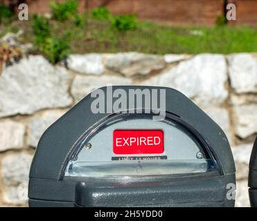 Compteur de stationnement de rue avec enseigne rouge expirée. Banque D'Images