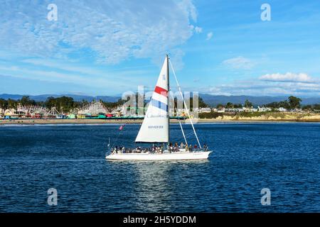 Un magnifique voilier avec des touristes flotte le long du pittoresque parc d'attractions Santa Cruz Beach Boardwalk - Santa Cruz, Californie, Etats-Unis - novembre 2021 Banque D'Images