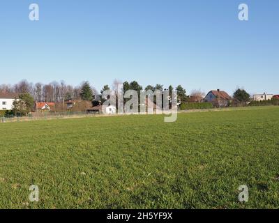 Terrain vert et maisons à la ville européenne de Bielsko-Biala dans le quartier de Silésie en Pologne, ciel bleu clair en 2020 chaude journée de printemps ensoleillée le mois d'avril. Banque D'Images