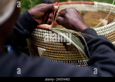 Septembre 2017.Les femmes avec un groupe d'artisans locaux apprennent à tisser des paniers traditionnels comme l'artisanat pour la vente aux touristes.L'organisation favorise une collaboration étroite entre les membres, et ils s'aident souvent les uns les autres avec de petits prêts et des compétences techniques.Malheureusement, ils ont été expulsés de leur atelier précédent et de leur salle d'exposition et sont maintenant à la recherche d'un autre emplacement.Nkuringo, Ouganda. Banque D'Images