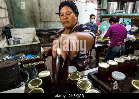 Juillet 2017.Elizabeth Palcay, chef cuisinier, effectue les contrôles de qualité finaux et termine l'emballage de la gelée d'hibiscus.La Kalihan Educational Foundation (KEF) gère une petite confiture, gelée, et d'autres aliments préparés faisant opération dans le cadre de leurs programmes de développement d'entreprise.Imugan, Nueva Vizcaya, Philippines. Banque D'Images