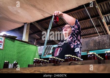 Juillet 2017.Elizabeth Palcay, chef cuisinier, effectue les contrôles de qualité finaux et termine l'emballage de la gelée d'hibiscus.La Kalihan Educational Foundation (KEF) gère une petite confiture, gelée, et d'autres aliments préparés faisant opération dans le cadre de leurs programmes de développement d'entreprise.Imugan, Nueva Vizcaya, Philippines. Banque D'Images