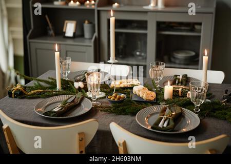 Image d'arrière-plan de table confortable décorée pour Noël avec des bougies allumées dans les tons gris, espace de copie Banque D'Images