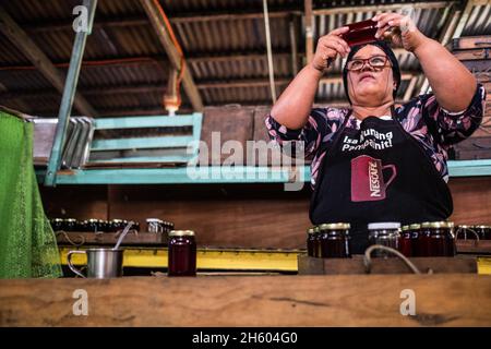 Juillet 2017.Elizabeth Palcay, chef cuisinier, effectue les contrôles de qualité finaux et termine l'emballage de la gelée d'hibiscus.La Kalihan Educational Foundation (KEF) gère une petite confiture, gelée, et d'autres aliments préparés faisant opération dans le cadre de leurs programmes de développement d'entreprise.Imugan, Nueva Vizcaya, Philippines. Banque D'Images