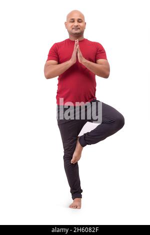 Portrait d'un homme chauve debout et faisant du yoga sur fond blanc Uni. Banque D'Images