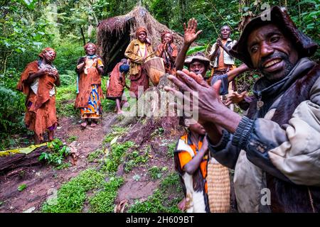 Septembre 2017.Le guide Batwa, Machate Emanuel, dirige la visite du sentier forestier communautaire de Buniga dans sa langue locale, les Pygmées de Batwa ont été expulsées de leurs terres d'origine dans la forêt au début des années 1990, lorsque les parcs nationaux ont été établis,les laisser sans terre et pauvres dans une société qui les considérait comme une classe inférieure.Aujourd'hui, certains d'entre eux essaient de faire la rencontre des extrémités en organisant des promenades sur les sentiers; des visites culturelles qui incluent des exemples de l'endroit et de la façon dont ils utilisent pour vivre dans la forêt, ainsi que du chant, de la danse et de l'artisanat pour la vente.Nkuringo, Ouganda. Banque D'Images