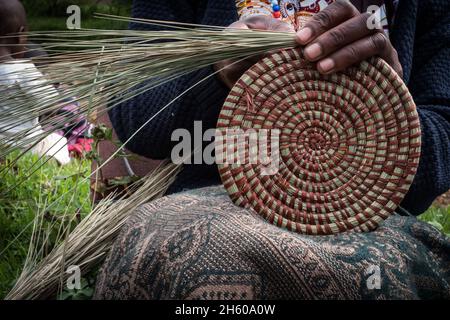 Septembre 2017.Les femmes avec un groupe d'artisans locaux apprennent à tisser des paniers traditionnels comme l'artisanat pour la vente aux touristes.L'organisation favorise une collaboration étroite entre les membres, et ils s'aident souvent les uns les autres avec de petits prêts et des compétences techniques.Malheureusement, ils ont été expulsés de leur atelier précédent et de leur salle d'exposition et sont maintenant à la recherche d'un autre emplacement.Nkuringo, Ouganda. Banque D'Images