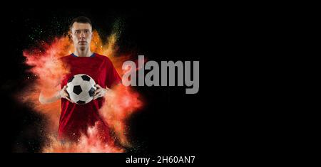 Collage créatif de jeune homme, entraînement professionnel de joueur de football isolé sur une explosion de poudre colorée sur fond noir.Circulaire Banque D'Images