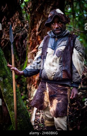 Septembre 2017.Le guide Batwa, Machate Emanuel, dirige la visite du sentier forestier communautaire de Buniga dans sa langue locale, les Pygmées de Batwa ont été expulsées de leurs terres d'origine dans la forêt au début des années 1990, lorsque les parcs nationaux ont été établis,les laisser sans terre et pauvres dans une société qui les considérait comme une classe inférieure.Aujourd'hui, certains d'entre eux essaient de faire la rencontre des extrémités en organisant des promenades sur les sentiers; des visites culturelles qui incluent des exemples de l'endroit et de la façon dont ils utilisent pour vivre dans la forêt, ainsi que du chant, de la danse et de l'artisanat pour la vente.Nkuringo, Ouganda. Banque D'Images