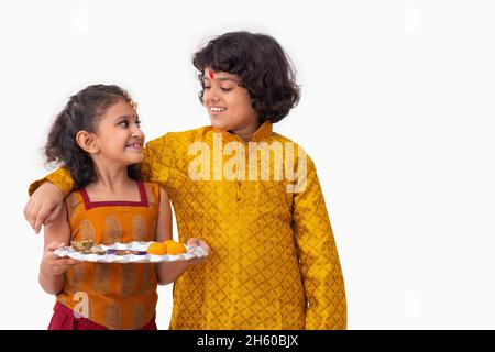 Portrait de frère et sœur debout avec un thaali à l'occasion de Bhai Dooj Banque D'Images