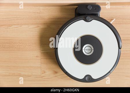 Aspirateur robot TopView Auto, garez-vous à la station de charge de la batterie avec un espace en bois pour le texte. Banque D'Images