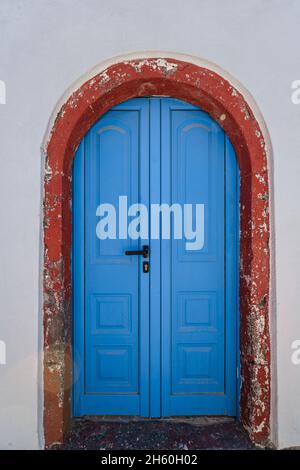 Porte en bois bleu et arrière-plans muraux des bâtiments traditionnels de l'île grecque Banque D'Images