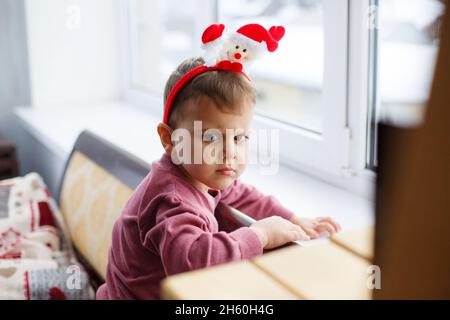 Mignon petit garçon en colère avec chapeau de fanny regardant l'appareil photo.Joli petit enfant près de la fenêtre. Banque D'Images