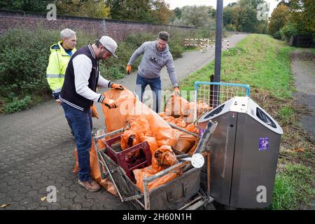 Équipés de pinces et de sacs à ordures recyclables, des volontaires de l'organisation environnementale KRAKE e.V. collectent des ordures sur la rive gauche du Rhin, devant le pont Leverkusen près de Cologne, le 26 octobre 2021 --- ausgestattet mit Greifzangen und recycelbaren Müllsäcken sammeln Freiwillige der Umweltorganization KRAKE e.V. das linkssheinische Ufer vor der Leverkusener Brücke BEI Köln Unrat und Müll.Köln, 26.10.2021 Banque D'Images