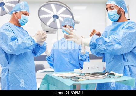 Équipe médicale de chirurgie en vêtements de protection et avec des gants stériles avant l'opération Banque D'Images