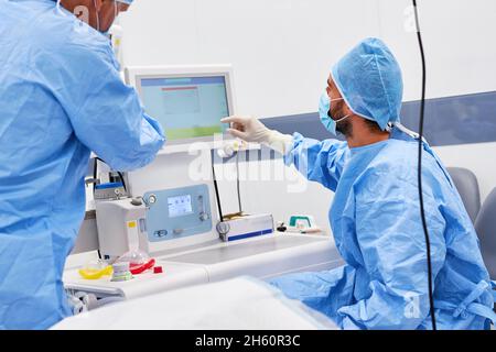 Le chirurgien et l'anesthésiste vérifient le patient sur le moniteur de surveillance pendant l'opération Banque D'Images