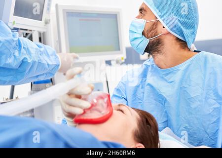 L'anesthésiste observe le moniteur sur le ventilateur pendant que le patient est anesthésié Banque D'Images