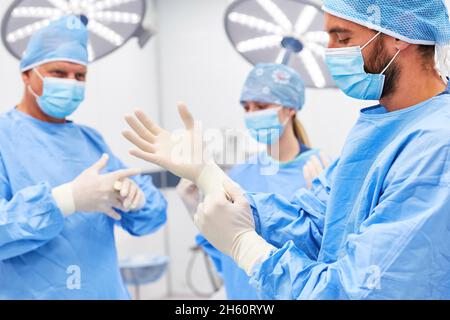 Les chirurgiens ont mis des gants jetables comme hygiène avant la chirurgie à l'hôpital Banque D'Images