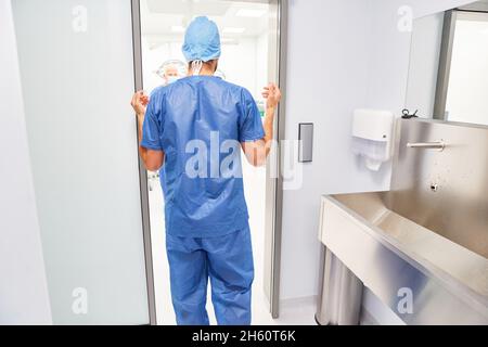 Chirurgien ou anesthésiste prêt à fonctionner après désinfection devant la salle d'opération Banque D'Images