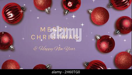 Image du texte joyeux noël sur les boules et la chute de neige Banque D'Images