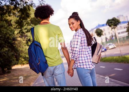 Arrière arrière derrière vue portrait de couple attrayant passer la date de jour ensoleillé week-end se promener allant tenant les mains à l'extérieur Banque D'Images