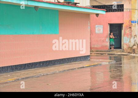 Scène de rue dans le centre de la Havane.Réflexions sur un jour pluvieux avec une femme à la porte, la Habana (la Havane), Habana, Cuba Banque D'Images
