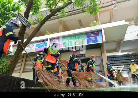 Bangkok, Thaïlande.12 novembre 2021.Les femmes de ménage nettoient le terrain pour la reprise des cours dans une école à Bangkok, Thaïlande, 12 novembre 2021.Les cas cumulés de COVID-19 en Thaïlande ont dépassé les 2 millions vendredi, alors que le pays a récemment levé les restrictions de voyage pour vacciner les visiteurs internationaux dans le but de relancer son économie tributaire du tourisme.Credit: Rachen Sageamsak/Xinhua/Alay Live News Banque D'Images