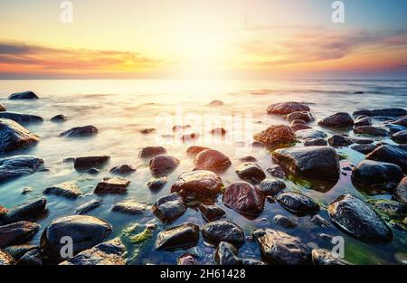 Rocky plage de la mer Baltique à un beau coucher de soleil, Pologne. Banque D'Images