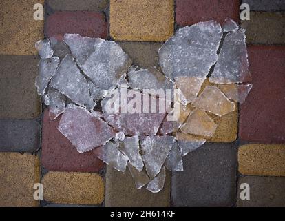 Coeur brisé fait de éclats de glace transparents sur les dalles de pavage. Triste Saint-Valentin.La fin de la relation.Émotions dépressives.L'amour a pa Banque D'Images