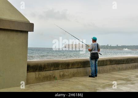 Scène de rue dans le centre de la Havane.Pêcheur avec surf s'écrasant sur le mur de la mer le long du Malecon, la Habana (la Havane), Habana, Cuba Banque D'Images