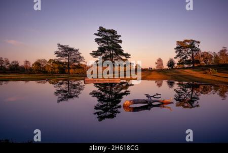 Une belle scène de paysage de réflexion au crépuscule montrant les couleurs automnales des fougères dans le New Forest Hampshire Angleterre. Banque D'Images