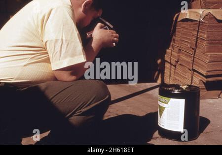 L'inspecteur des pesticides de l'agence de protection de l'environnement photographie l'étiquette d'un contenant à la Valley Chemical Company, Greenville, Mississippi, au cours d'une inspection de routine et le comparera avec les étiquettes EPA a dans le dossier; Mississippi ca.Mars 1974 Banque D'Images