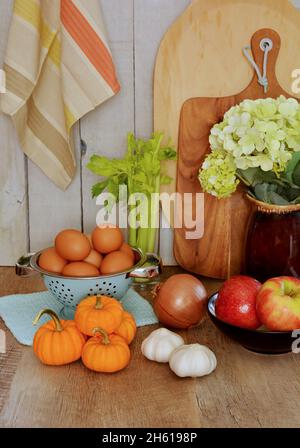 Fruits et légumes de l'automne avec planches à découper et torchon à thé dans un cadre rustique en format vertical. Banque D'Images