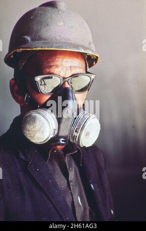 Un peintre en peinture au chantier naval d'Avondale porte un masque de protection respiratoire; région de la Nouvelle-Orléans ca.Janvier 1973 Banque D'Images