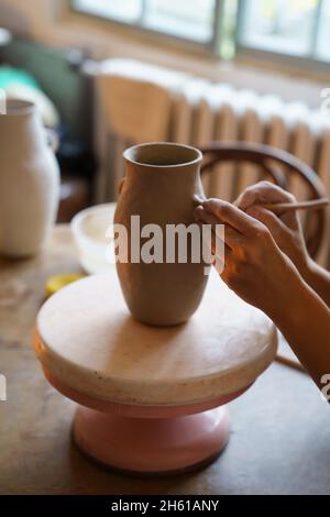 Poterie hobby: Mains de professionnel ceramiste travail sur vase potter en studio créer un pot d'argile brute Banque D'Images