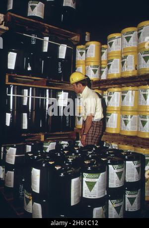 L'inspecteur des pesticides de l'agence de protection de l'environnement vérifie les étiquettes sur les contenants lors d'une inspection de routine de la Valley Chemical Company, Greenville, Mississippi ca.Mars 1974 Banque D'Images