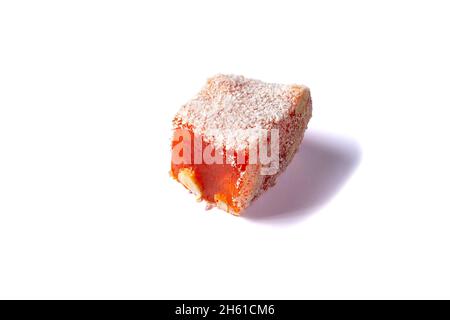 Délice turc isolé sur fond blanc.Flocons de noix de coco recouverts de lokum orange.Bonbons à la gelée de fruits et noisettes. Gros plan Banque D'Images