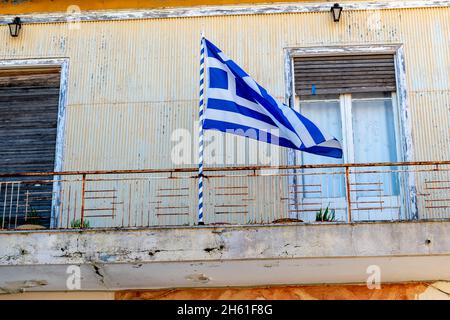 Le drapeau national grec volant sur le balcon d'un bâtiment pendant la célébration de l'anniversaire de l'Oxi Day à Lefkada, Grèce. Banque D'Images